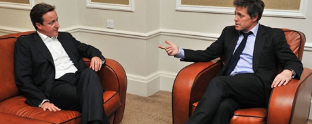 David Cameron and Hugh Grant sat on a Chesterfield sofa